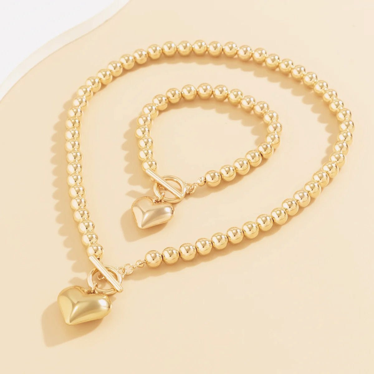 Calira - Beaded Heart Pendant Bracelet and Necklace Set Gold — perfect for those who value comfort and design. Calira - Beaded Heart Pendant Bracelet and Necklace Set Gold — perfect for those who value comfort and design.
