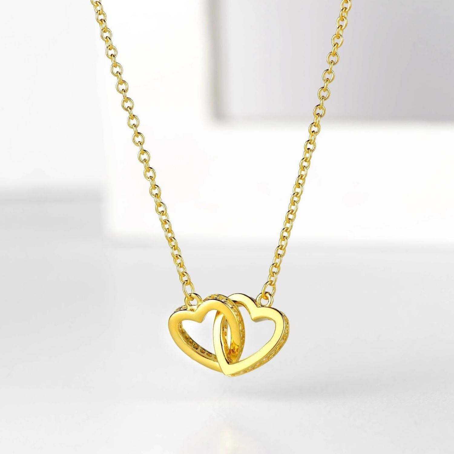 Emily - 'To My Daughter' Interlocking Gold Heart Necklace — bringing modern charm to your space. Emily - 'To My Daughter' Interlocking Gold Heart Necklace — bringing modern charm to your space.